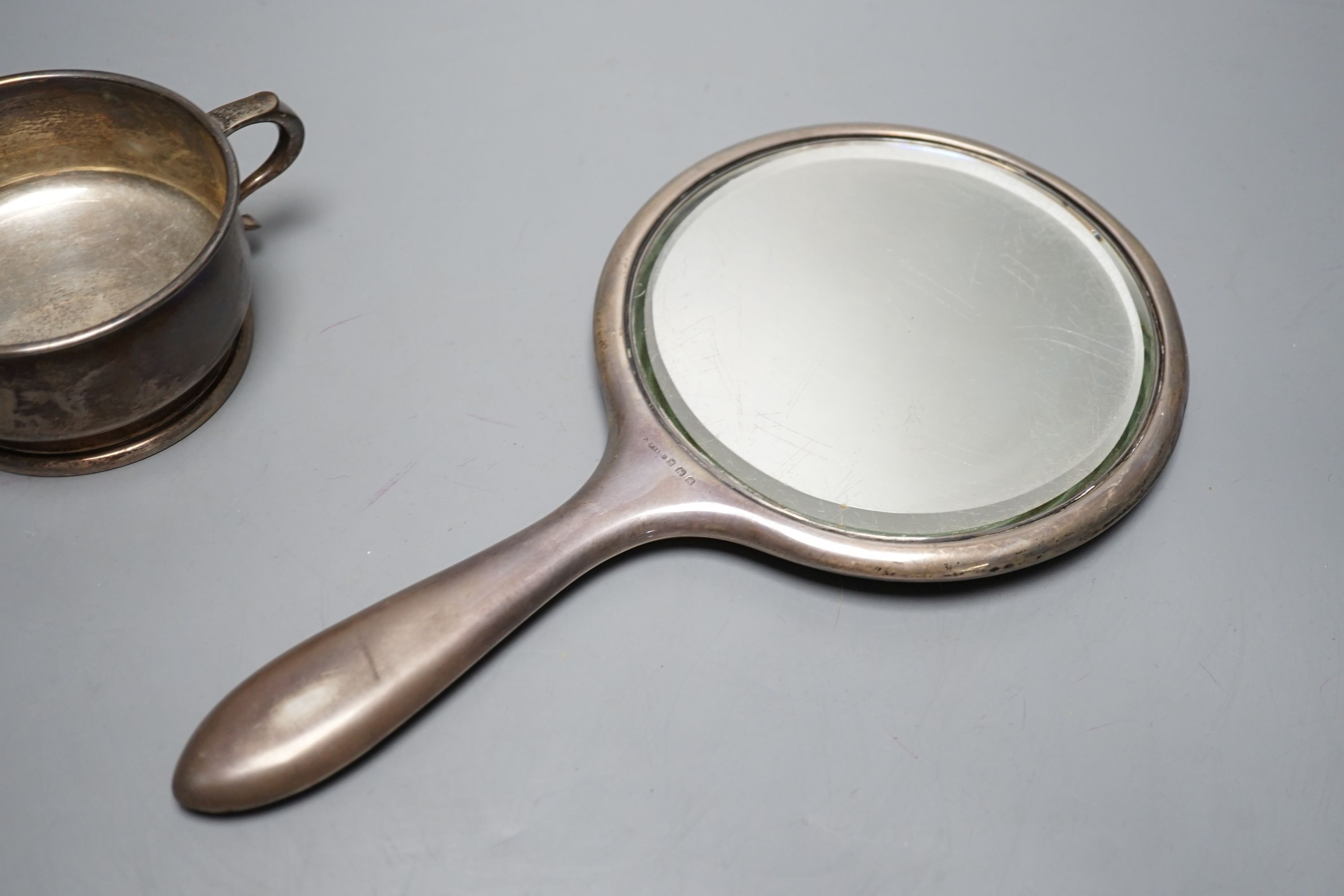 A silver two handled bowl, a silver mounted hand mirror, two silver and mother of pearl fruit knives, a silver preserve spoon and enamelled compact decorated with a dog.